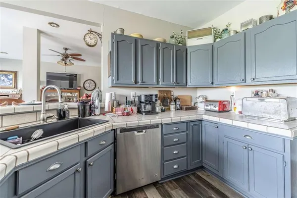 a kitchen with cabinets appliances a sink and a counter top space