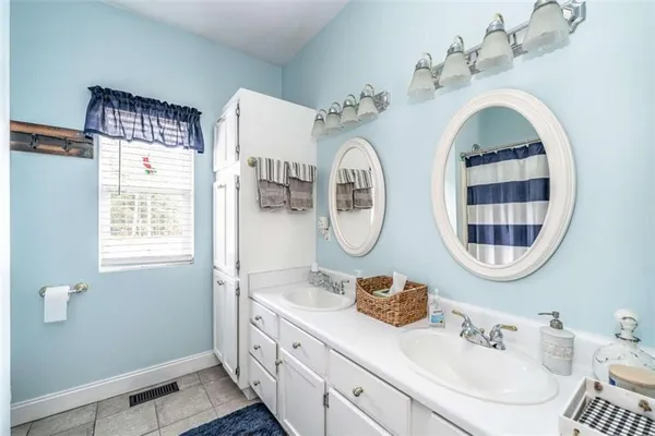 a bathroom with a double vanity sink and a mirror