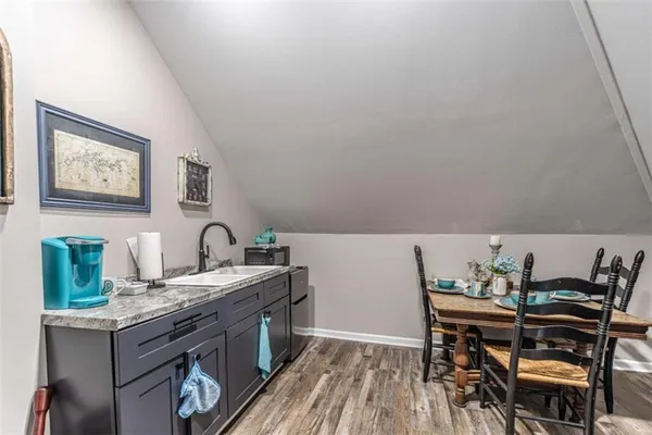 a bedroom with a bed a computer on desk and a dresser next to a window