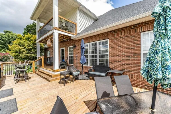 a patio with wooden floor and outdoor seating