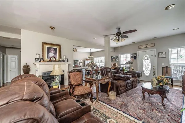 a living room with furniture a fireplace and a chandelier