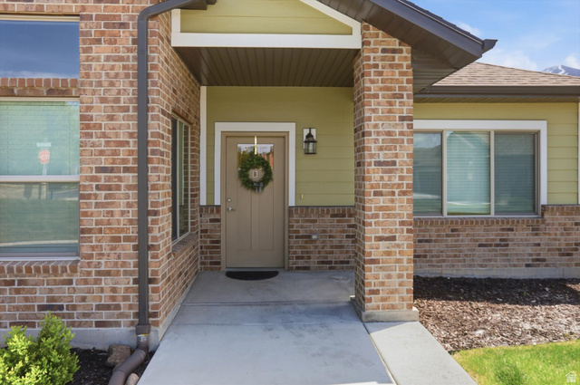 1838 West 300th Street South, Unit B Mapleton, UT 84664 - Photo 2 of 51 Covered entryway featuring a beige door with a transom window and an exterior wall lantern