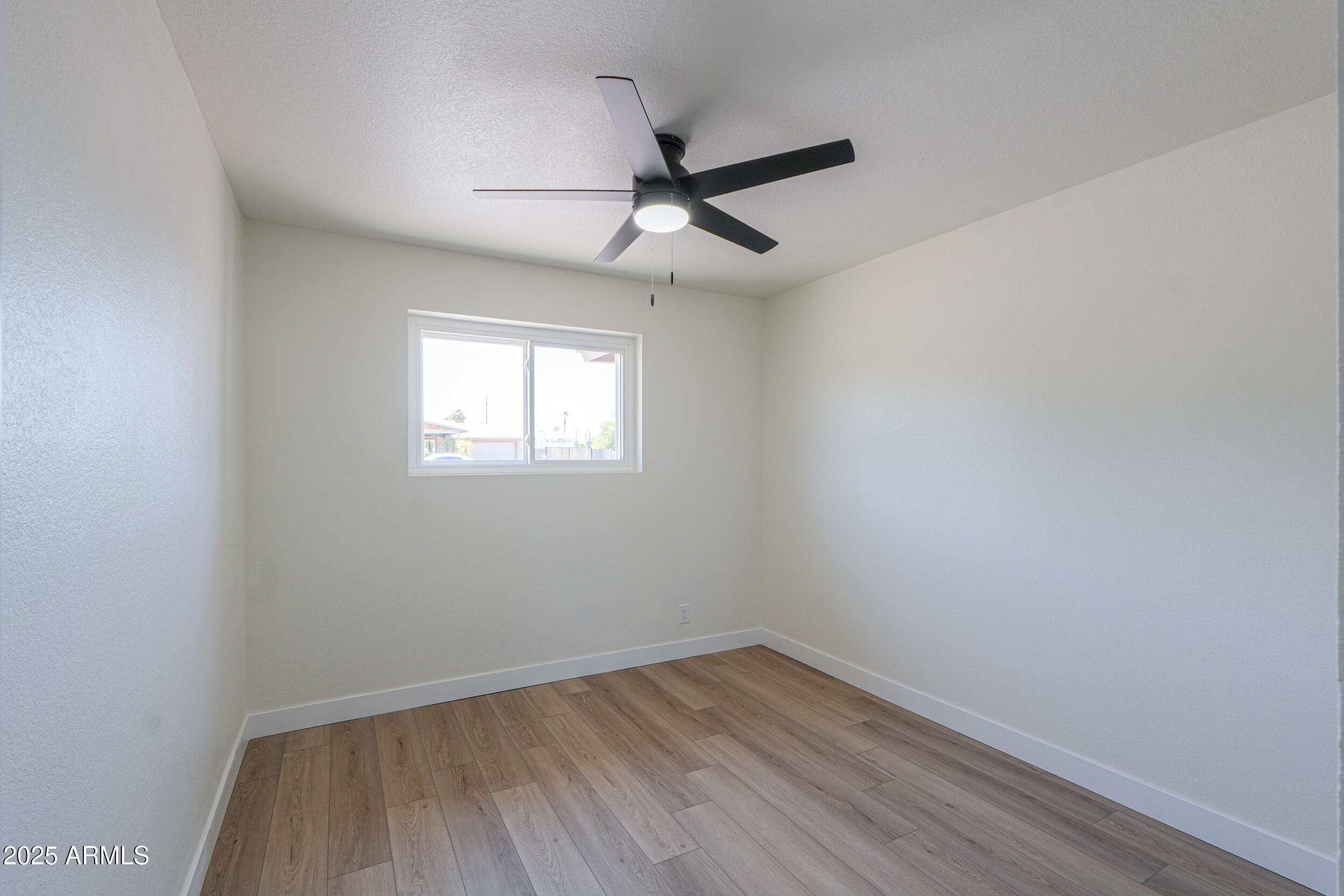 6502 East Rustic Drive Mesa, AZ 85215 - Photo 20 of 40 an empty room with a window and wooden floor
