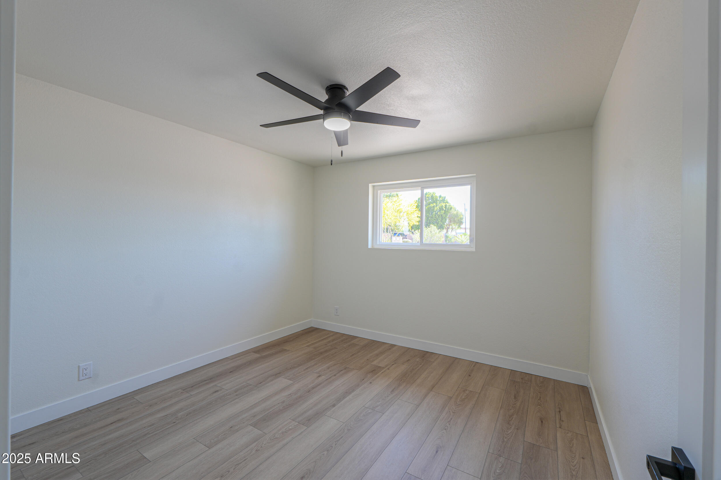6502 East Rustic Drive Mesa, AZ 85215 - Photo 22 of 40 an empty room with wooden floor fan and windows