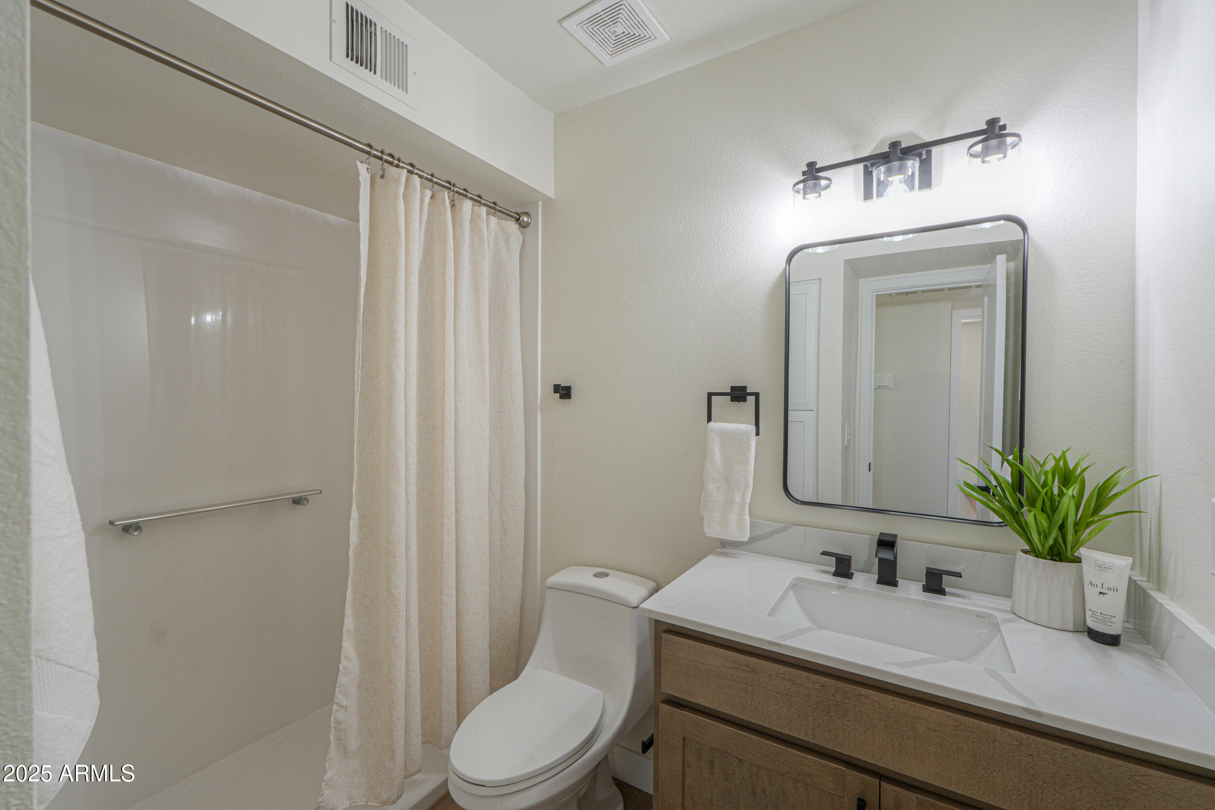 6502 East Rustic Drive Mesa, AZ 85215 - Photo 24 of 40 a bathroom with a toilet a sink and mirror
