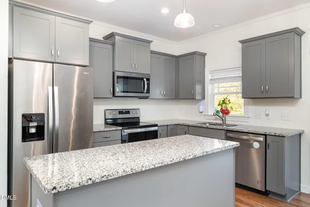 a kitchen with granite countertop a refrigerator and a sink