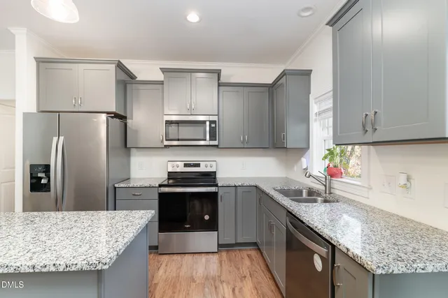 a kitchen with stainless steel appliances granite countertop a sink stove and refrigerator
