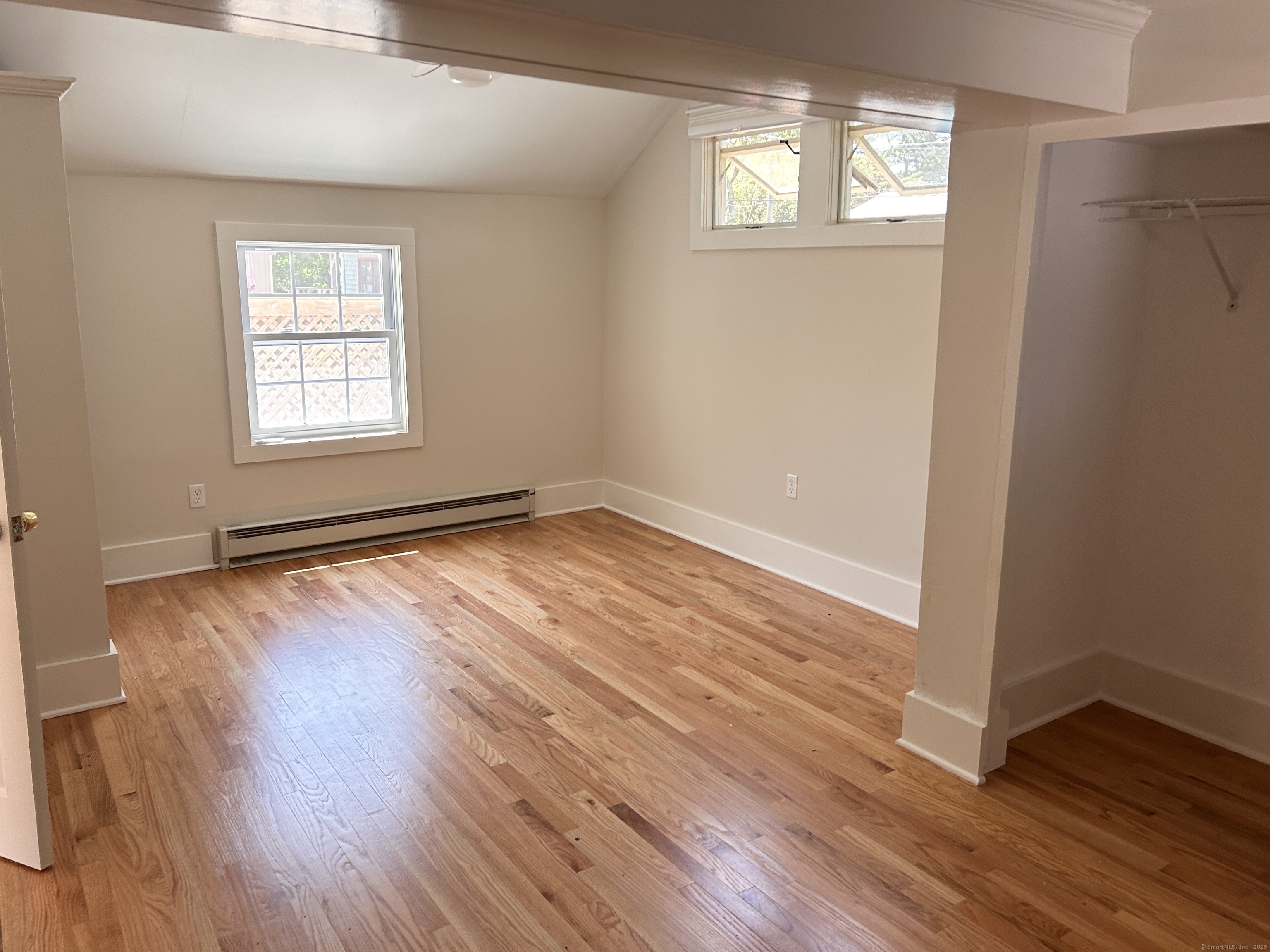 6-5 5th Street, Unit 6 Madison, CT 06443 - Photo 25 of 29 an empty room with wooden floor and windows