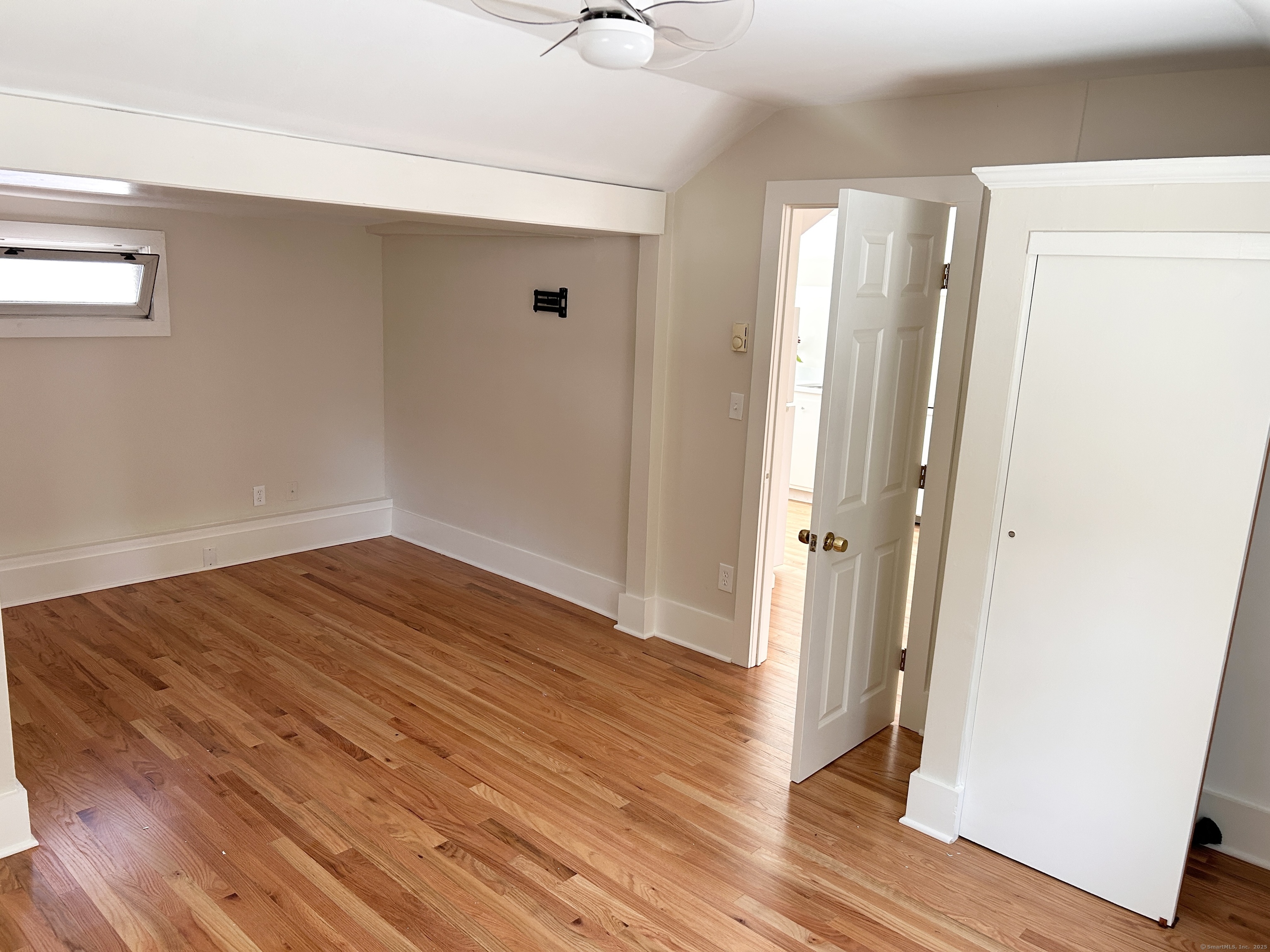 6-5 5th Street, Unit 6 Madison, CT 06443 - Photo 26 of 29 an empty room with wooden floor and windows