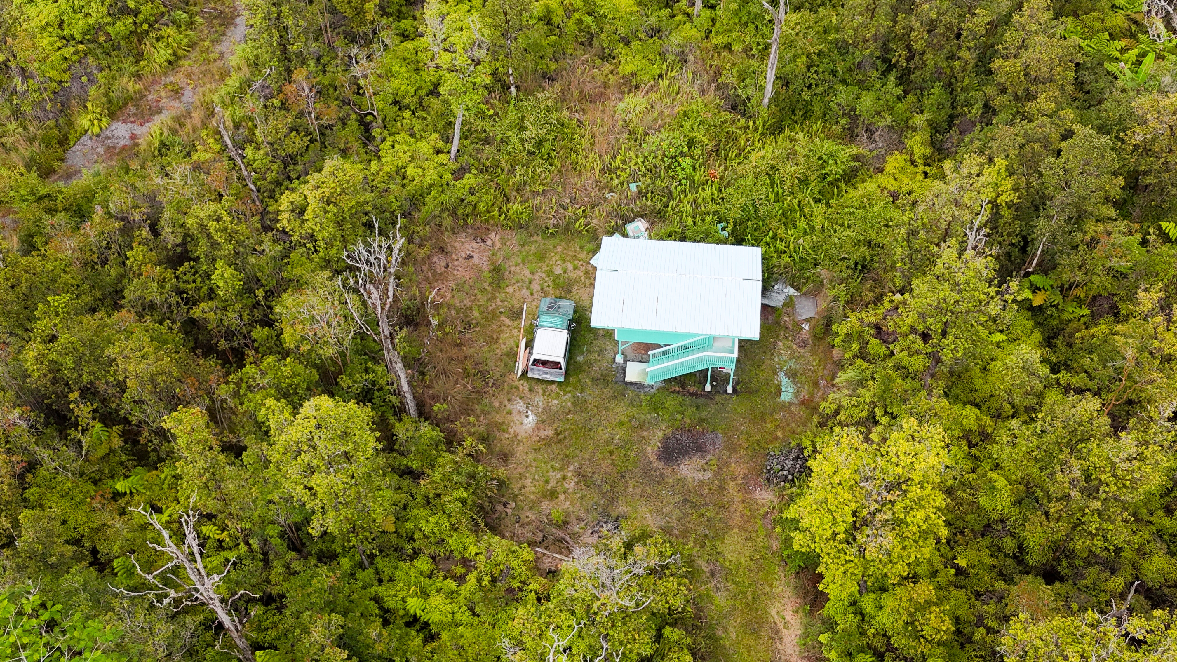 21 Palainui Street Pahoa, HI 96778 - Photo 1 of 8 a bench sitting in middle of a yard