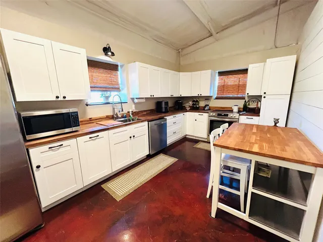 a kitchen with granite countertop a stove and white cabinets