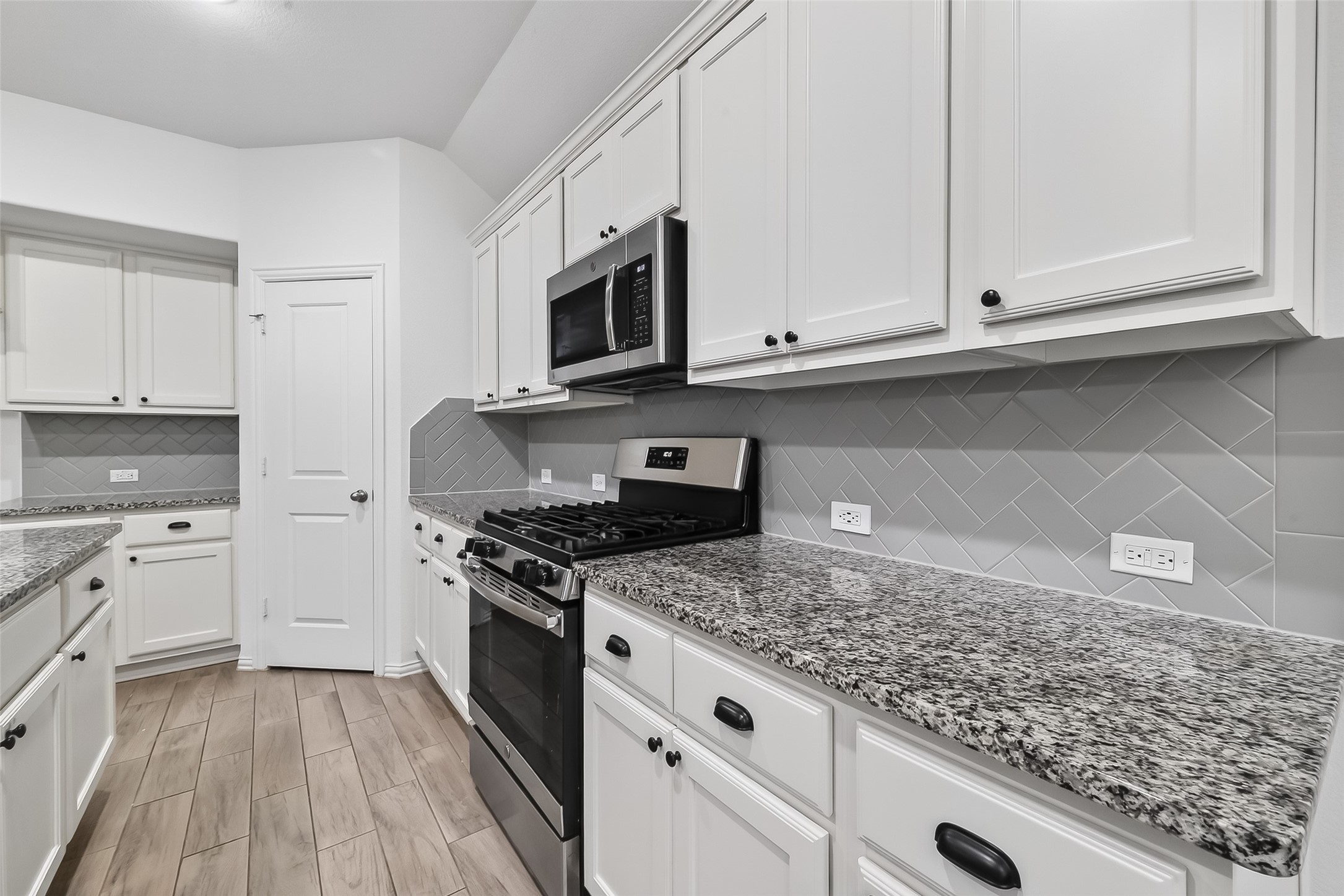 210 Emory Birch Montgomery, TX 77316 - Photo 22 of 48 a kitchen with granite countertop white cabinets and appliances