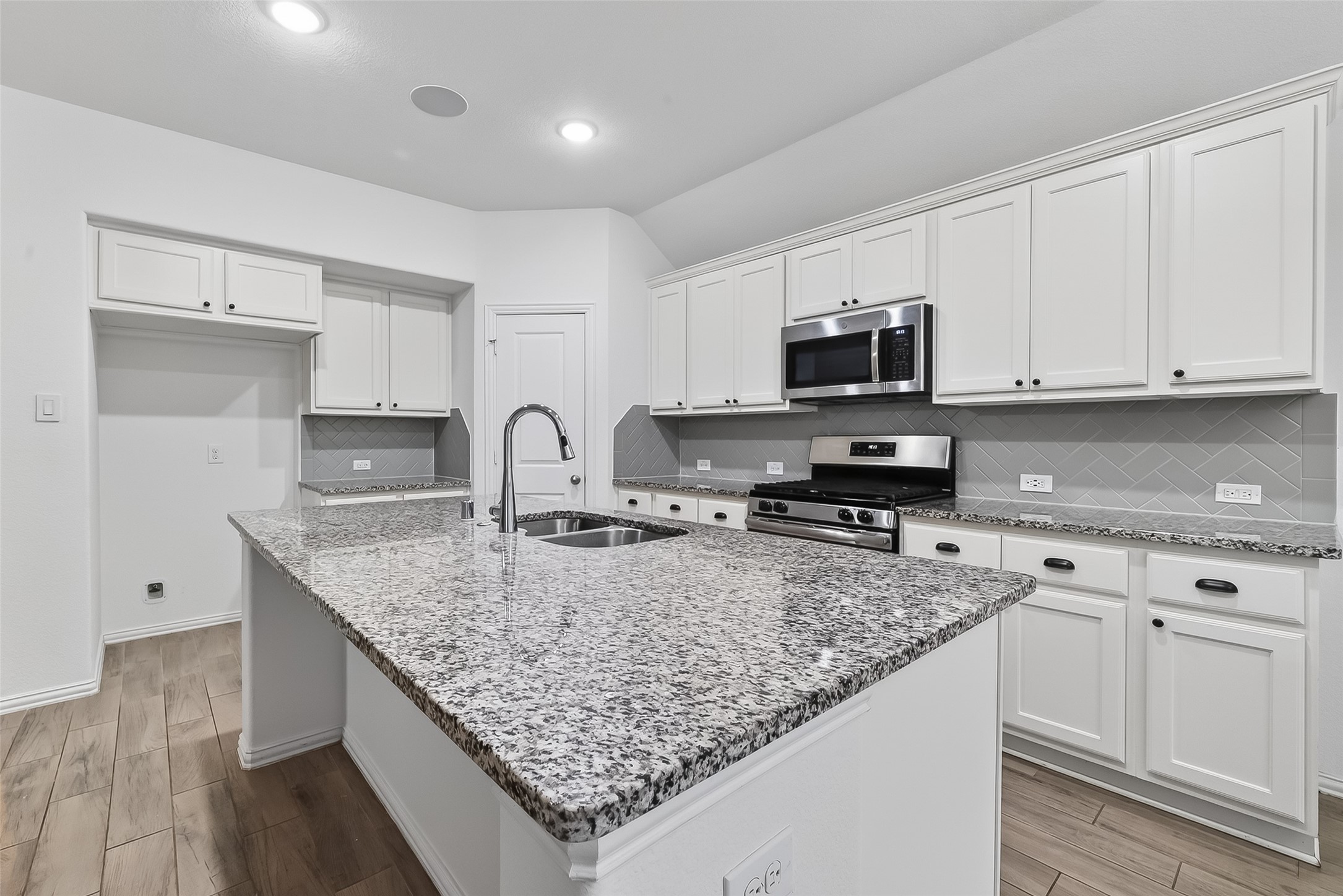 210 Emory Birch Montgomery, TX 77316 - Photo 23 of 48 a kitchen with granite countertop a sink and white cabinets