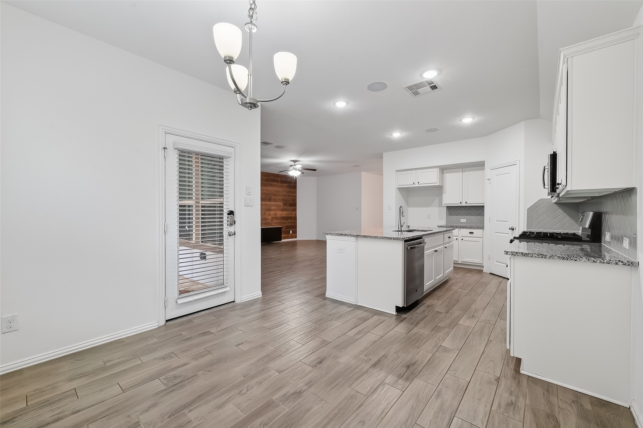 210 Emory Birch Montgomery, TX 77316 - Photo 24 of 48 a kitchen with stainless steel appliances granite countertop a refrigerator a stove oven and white cabinets with wooden floor