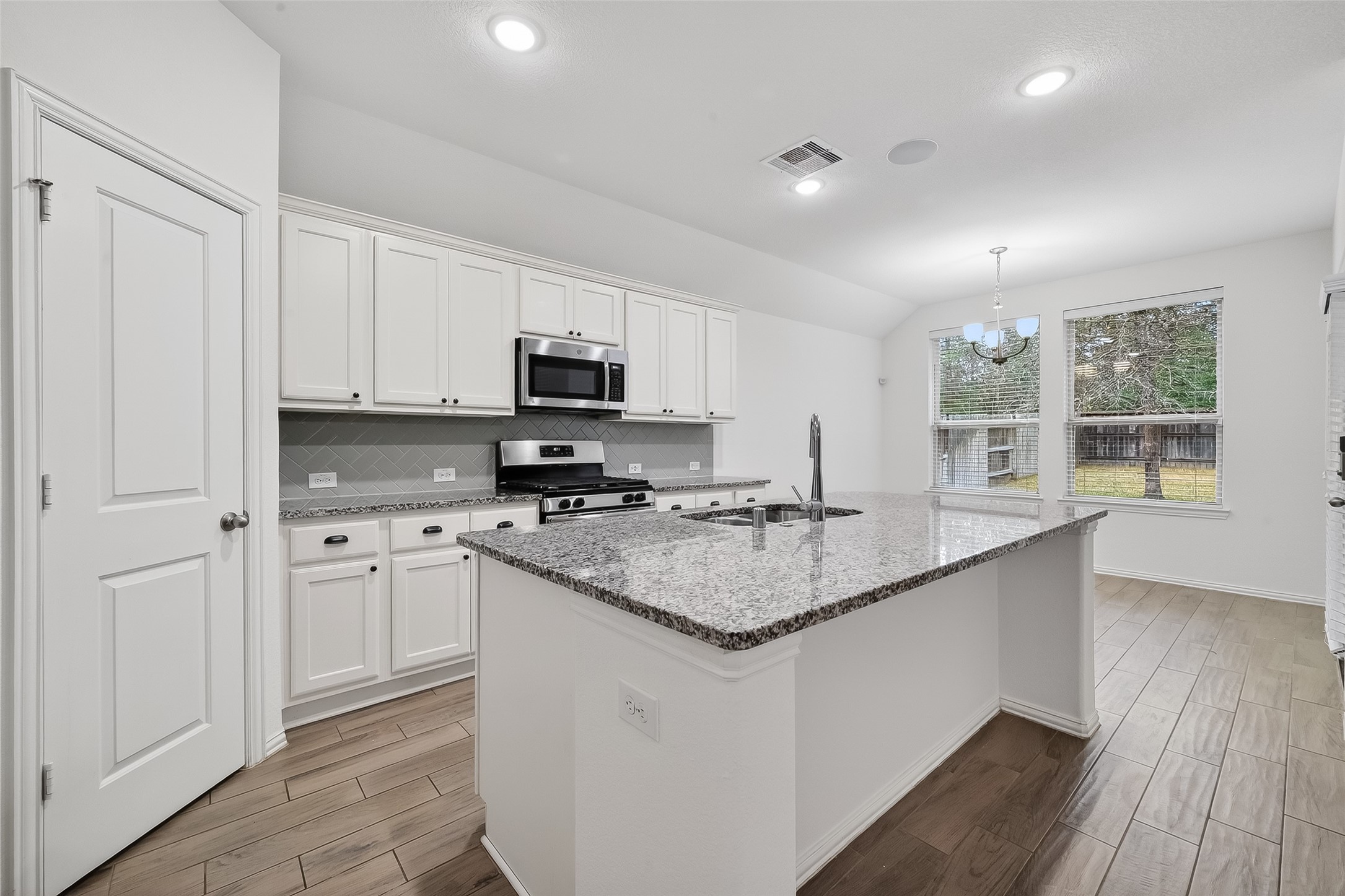 210 Emory Birch Montgomery, TX 77316 - Photo 27 of 48 a kitchen with stainless steel appliances granite countertop a stove a sink and a microwave