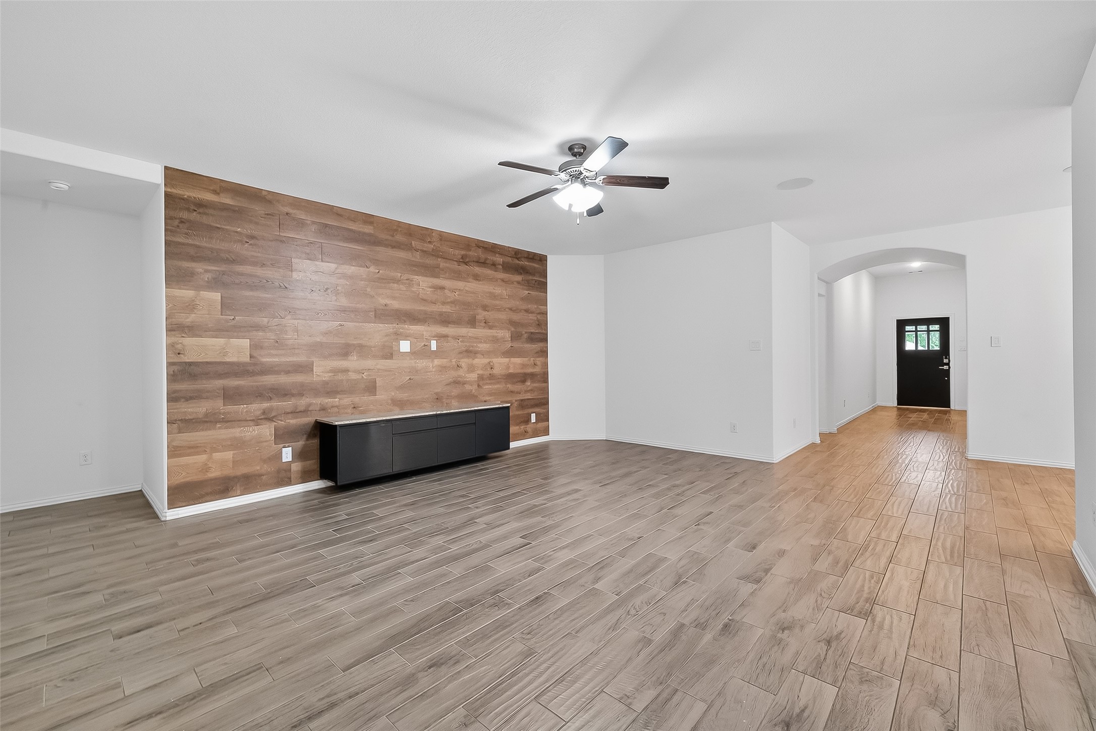 210 Emory Birch Montgomery, TX 77316 - Photo 9 of 48 a view of an empty room with wooden floor and a ceiling fan