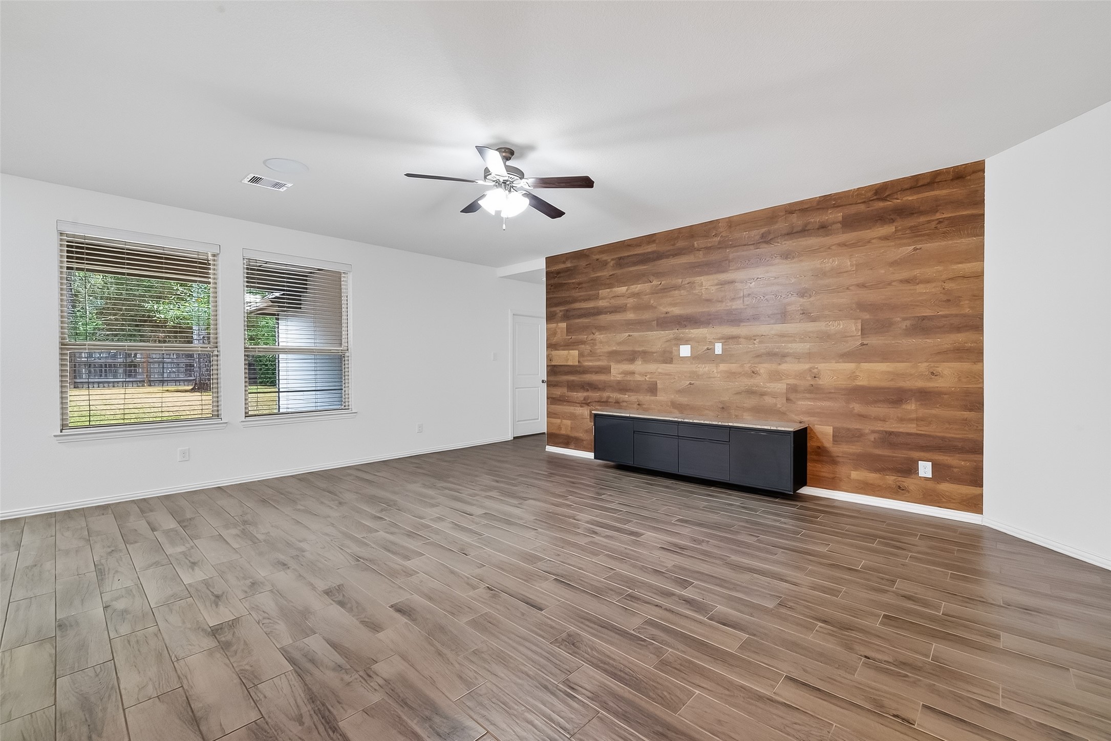 210 Emory Birch Montgomery, TX 77316 - Photo 10 of 48 a view of an empty room with a window and wooden floor