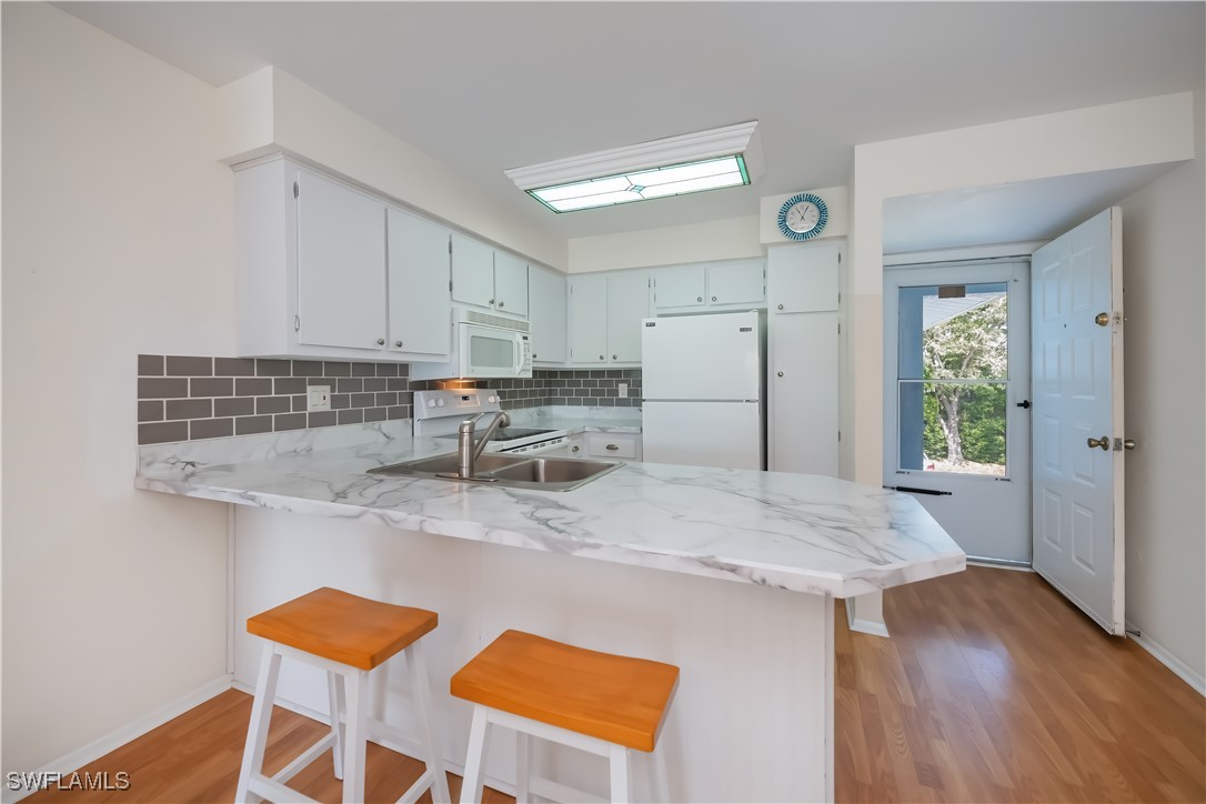 1100 Pondella Road, Unit 514 Cape Coral, FL 33909 - Photo 14 of 35 a kitchen with stainless steel appliances granite countertop a table chairs sink and cabinets