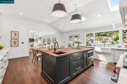 a kitchen with a stove and wooden floor