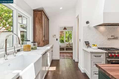 a kitchen with stainless steel appliances a stove a sink and wooden floor