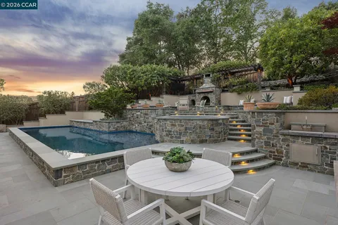 a roof deck with table and chairs and potted plants