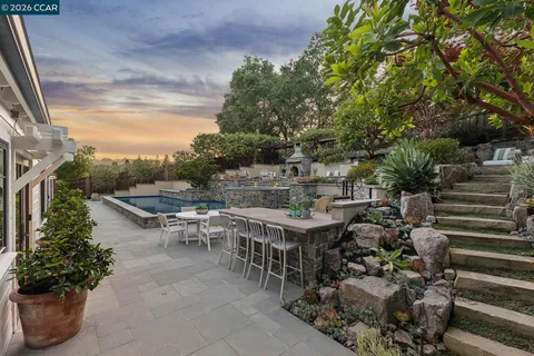 a view of a patio with table and chairs potted plants with wooden floor and fence