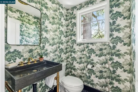 a bathroom with a toilet a sink and a window