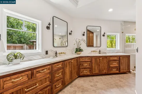 a spacious bathroom with a granite countertop double vanity sink and a window