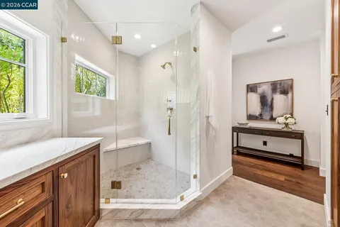 a bathroom with a granite countertop sink a mirror and a shower