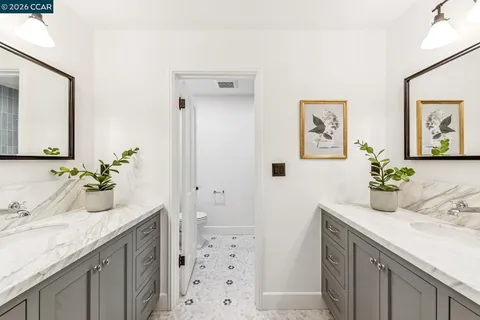 a bathroom with a granite countertop sink a mirror and a shower