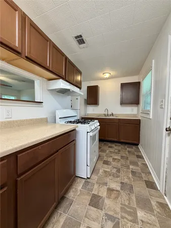 a kitchen with a sink a counter top space cabinets and stainless steel appliances