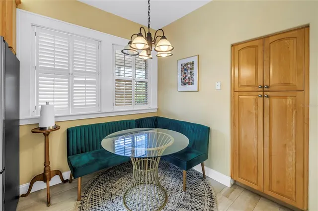 a kitchen with a refrigerator a microwave oven dining table and chairs