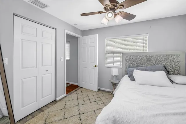 a bedroom with a large bed ceiling fan and a window