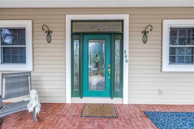 a kitchen with stainless steel appliances a stove a refrigerator a kitchen island a dining table and chairs