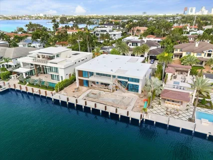 an aerial view of residential houses with outdoor space and ocean view