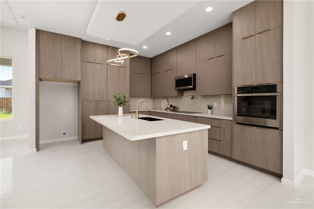 9119 North 25th Street McAllen, TX 78504 - Photo 12 of 22 a kitchen that has a sink and a stove in it