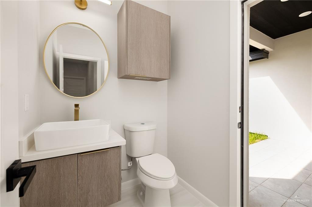 9119 North 25th Street McAllen, TX 78504 - Photo 14 of 22 a bathroom with a toilet a sink and a mirror