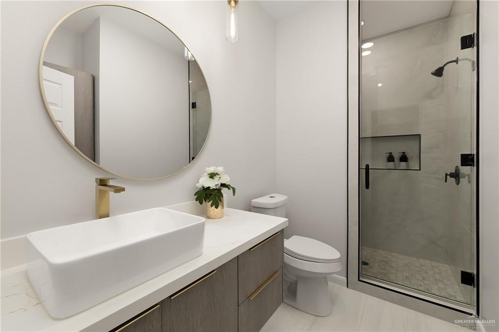 9119 North 25th Street McAllen, TX 78504 - Photo 19 of 22 a bathroom with a sink a toilet and a mirror