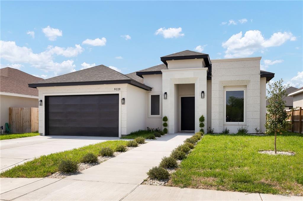 9119 North 25th Street McAllen, TX 78504 - Photo 2 of 22 a front view of a house with a yard and garage