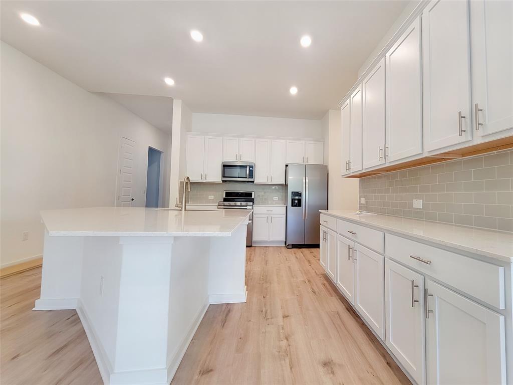 2032 Bobtail Pass Leander, TX 78641 - Photo 3 of 18 a kitchen with stainless steel appliances a refrigerator sink and cabinets