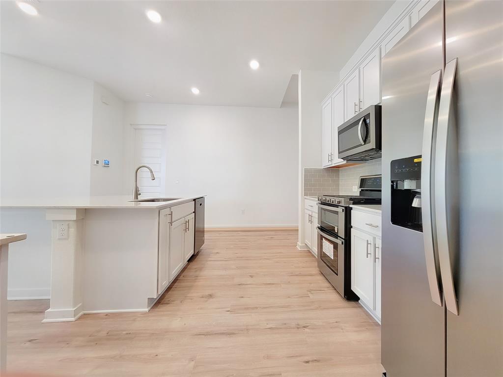 2032 Bobtail Pass Leander, TX 78641 - Photo 4 of 18 a kitchen with stainless steel appliances a refrigerator and a stove