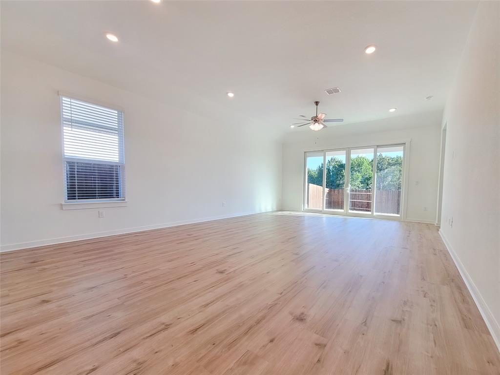 2032 Bobtail Pass Leander, TX 78641 - Photo 5 of 18 a view of an empty room with wooden floor and a window