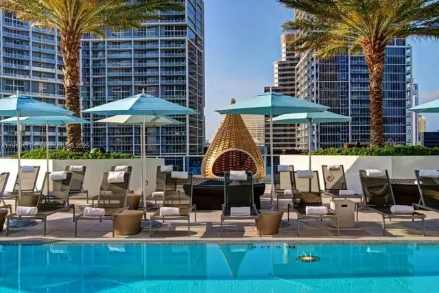 a view of a patio with couches table and chairs under an umbrella