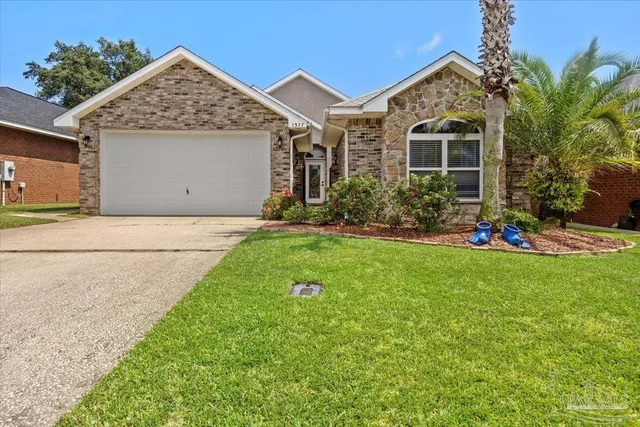 a front view of a house with a yard and potted plants