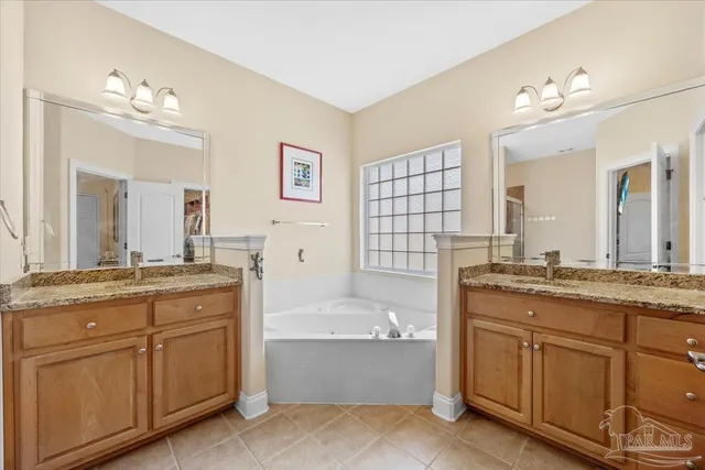 a bathroom with a granite countertop sink mirror and bathtub