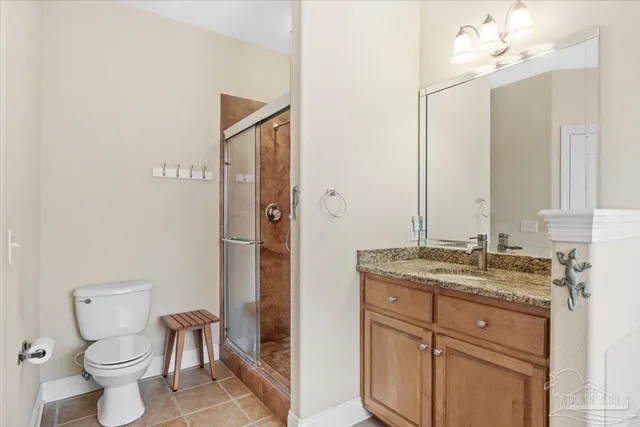 a bathroom with a granite countertop sink toilet a mirror and shower