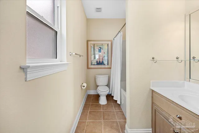 a bathroom with a granite countertop toilet a sink and a mirror