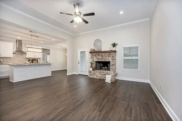 an empty room with wooden floor a fireplace and windows