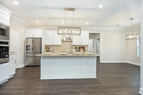 a kitchen with stainless steel appliances a refrigerator and a stove top oven