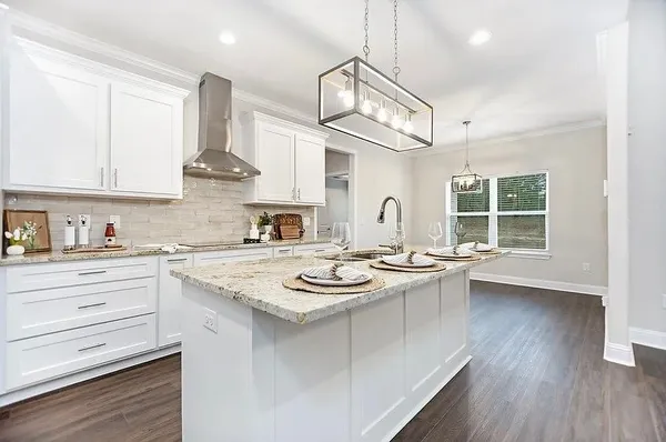 a kitchen with a sink a stove cabinets and wooden floor